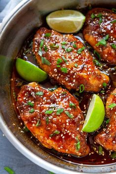 chicken with sesame seeds and limes in a skillet, ready to be eaten