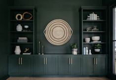 a living room with dark green walls and shelves filled with books, vases and other items