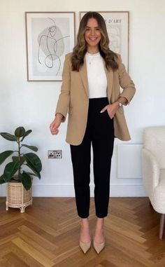 An outfit consisting of a beige coat, white tee, black trousers, and nude heels creates a chic and sophisticated look for workwear. The beige coat is a versatile and timeless piece that can add a touch of elegance to any outfit. The white tee should be a simple, well-fitted, and comfortable basic that can be worn tucked into the black trousers. With this outfit, you'll look confident, professional, and stylish for any work setting. Women Office Outfits