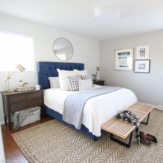 a bedroom with a bed, dresser and pictures on the wall above it is shown