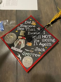 a graduation cap that has been decorated with images and words on it, sitting on top of a wooden table