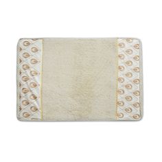 a bath mat with an embroidered design on the front and side, in gold and white