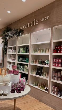 the candle shop is filled with candles and other holiday decorating items in white shelves