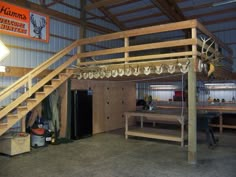 the inside of a building with wooden stairs and deer heads hanging from it's ceiling