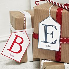 two presents wrapped in brown paper with red and white ribbon tied around them, one has a gift tag that says e