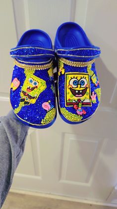 someone is holding up their blue spongebob clogs to the door with them