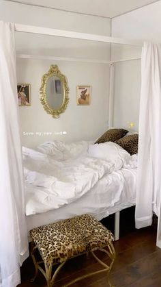 a bed with white sheets and leopard print foot stools in front of the bed