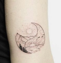 a black and white photo of a half moon tattoo on the right inner arm, with mountains in the background