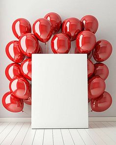 a white box surrounded by red balloons in front of a white wall with an empty sheet on the floor