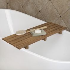 a bath tub with a wooden tray on it