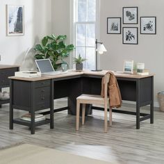 an office desk with a laptop on it and a chair in front of the desk