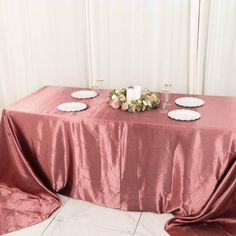 the table is set up with plates and flowers on it for an elegant wedding reception