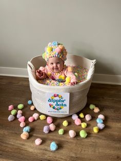 a baby sitting in a basket filled with candies