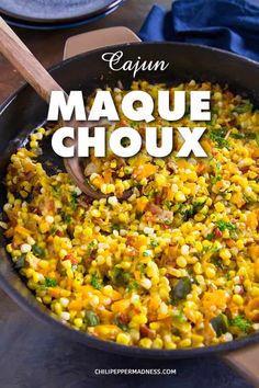 a skillet filled with corn and broccoli on top of a wooden table