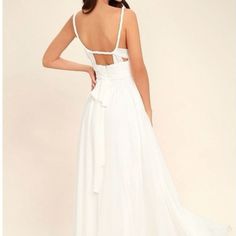 a woman wearing a white dress with a backless neckline and bow at the waist