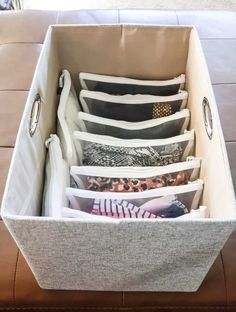 the inside of a storage bin filled with pillows and other decorative items on a couch