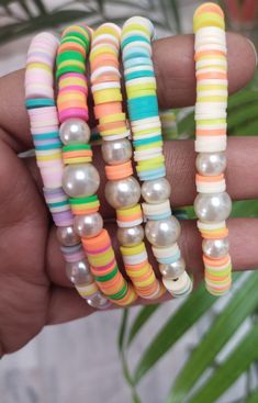 four different colored bracelets with pearls and beads on each stranded beaded wrist