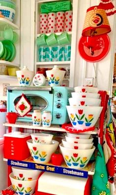 an assortment of colorful dishes on display in a kitchen