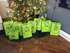 green wrapped presents sitting in front of a christmas tree