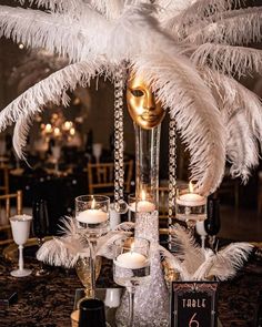 an elaborate centerpiece with feathers and candles