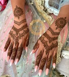 two hands with henna tattoos on them