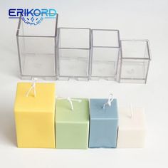 four different colored boxes sitting next to each other on a white surface with string tied around them