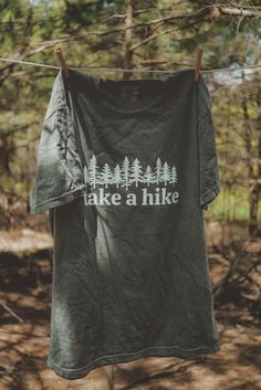 Take A Hike graphic t-shirt. Each t-shirt is pressed house on a comfort colors unisex shirt. T-shirts are made of a soft cotton blend and features a vibrant direct to fabric transfer design that won't fade or crack. COLOR PICTURED: HEMP Shop our wanderlust inspired t-shirt collection. Perfect for those who enjoy hiking, camping, exploring the outdoors and all adventure seeking enthusiasts. keywords: take a hike, outsider hiking shirt, wanderlust t-shirt, adventure t-shirts, graphic tees, unisex Take A Hike Shirt, Cotton Crew Neck T-shirt For Outdoor Activities, Custom Print Short Sleeve T-shirt For Outdoor, Green T-shirt For Outdoor Activities, Green Graphic Tee For Outdoor, Green Graphic Print T-shirt For Camping, Green Graphic Tee For Outdoor Activities, Cotton T-shirt With Letter Print For Camping, Graphic Tee For Camping With Graphic Print