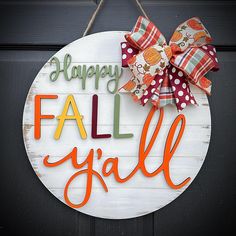 a sign that says happy fall y'all hanging on a door with a bow