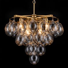 a chandelier with clear glass balls hanging from it's brass finish frame