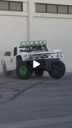 a white truck driving down a street next to a building