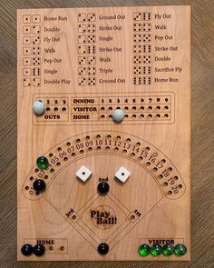 a wooden board game with numbers and dices on the front, including two balls