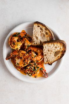 a white plate topped with shrimp and bread