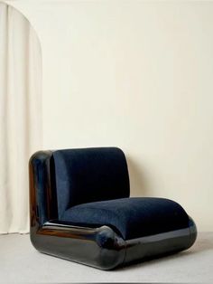 a blue chair sitting in front of a white wall