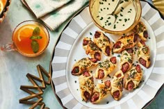 small appetizers are served on a plate with orange juice