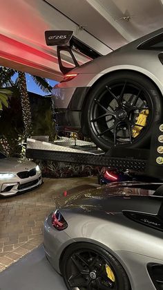 two cars are parked in a garage with their wheels on the back of one car