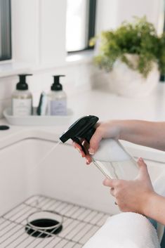 a woman is washing her hands in the sink with soap and lotion on it