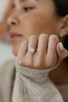 a woman wearing a ring with a diamond on it