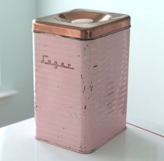 a pink canister sitting on top of a white counter