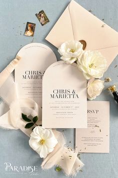 the wedding stationery is laid out on top of the blue table cloth with white flowers