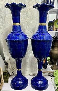 two blue vases sitting on top of a table