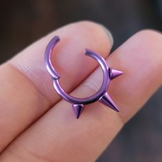 a person is holding a purple ring with spikes on it