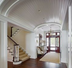 an entry way with stairs and a chandelier in the center, along with a door leading to another room