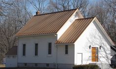 a small white church with a brown roof