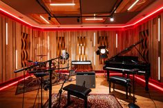 a recording room with two microphones, a piano and a keyboard in it's center