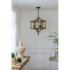 a chandelier hanging from the ceiling in a room with white walls and wood flooring