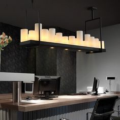 an office desk with candles hanging from it's ceiling and flowers on the counter