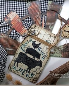 an assortment of wooden signs and tags on a white tablecloth with gingham checkered fabric