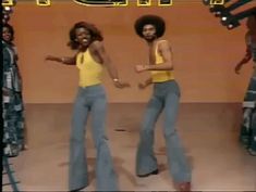 two women in blue jeans and yellow top dancing