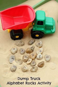 an image of a dump truck on the beach with rocks and sand in front of it