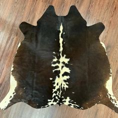 a black and white cowhide rug on a wooden floor